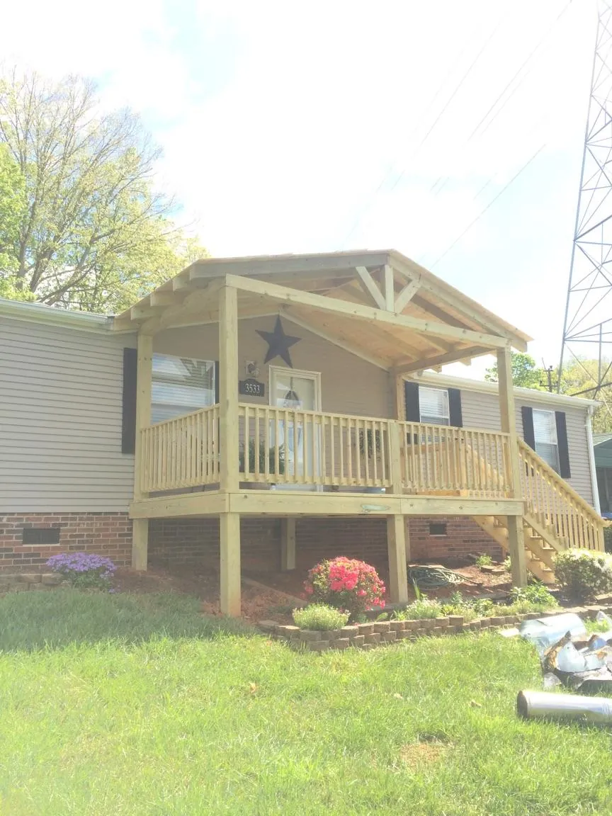 New gabled porch roof and deck railing added to a ranch home in Peterboro